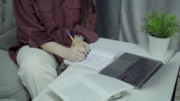 Visão superior das mãos da mulher com laptop fazer anotações em papéis, educação em casa — Vídeo de Stock