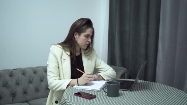 Mulher estudante com laptop fazer anotações em papéis, interior da casa — Vídeo de Stock