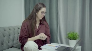 İnternetteki konferansta gözlüklü kadın öğrenci, ev içi.