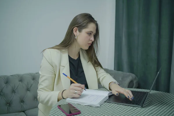 Dizüstü bilgisayarı olan bir kadın öğrenci evle ilgili notlar alıyor. — Stok fotoğraf