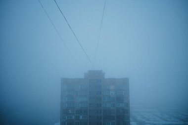 Evin çatısı kalın sisli, karanlık gökyüzü