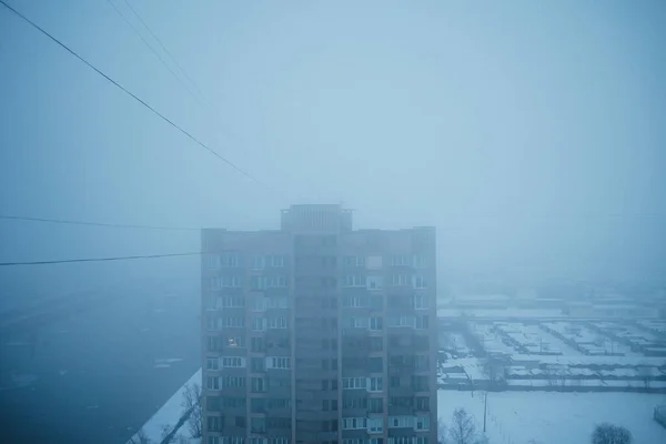 Telhado da casa em denso nevoeiro, céu azul escuro — Fotografia de Stock