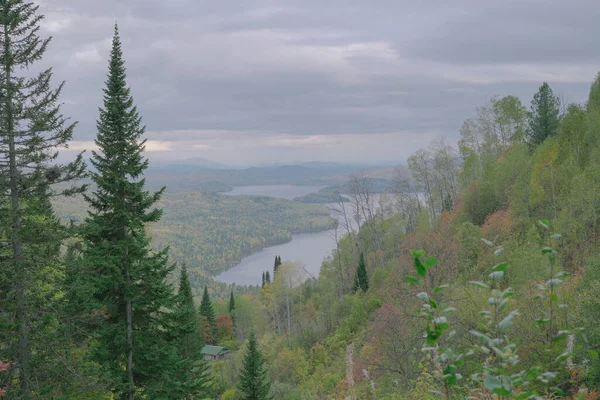 Tepeleri ve dağları olan kırsal bölge, göl ve bulutlu panoramik manzara