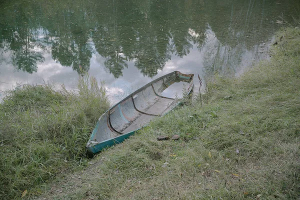 Stara łódź na rzece na wybrzeżu, odbicie jeziora i drzew — Zdjęcie stockowe