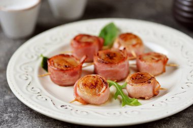 Domuz pastırmasında kızartılmış deniz tarağı..