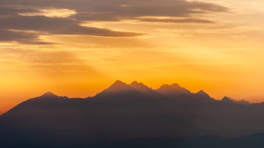 Batan turuncu güneş, Tatra Dağları, Polonya 'daki karanlık dağ zirveleri