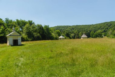 Güneşli bir yaz gününde, Polonya 'nın Kalwaria Paclawska kentinde tarlalar ve ormanlarla çevrili bir şapel.