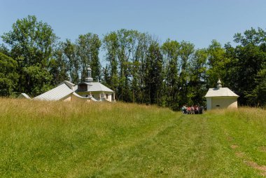 Güneşli bir yaz gününde, Polonya 'nın Kalwaria Paclawska kentinde tarlalar ve ormanlarla çevrili bir şapel.