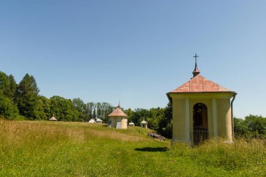 Güneşli bir yaz gününde, Polonya 'nın Kalwaria Paclawska kentinde tarlalar ve ormanlarla çevrili bir şapel.