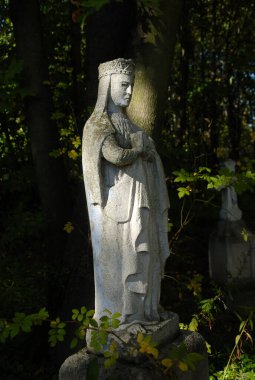 Karanlık bir arka planda Meryem Ana 'nın taş heykeli, Lublin, Polonya