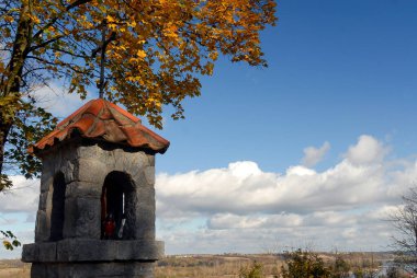 Sonbahar güneşli bir günde yol kenarı tapınağı, Polonya