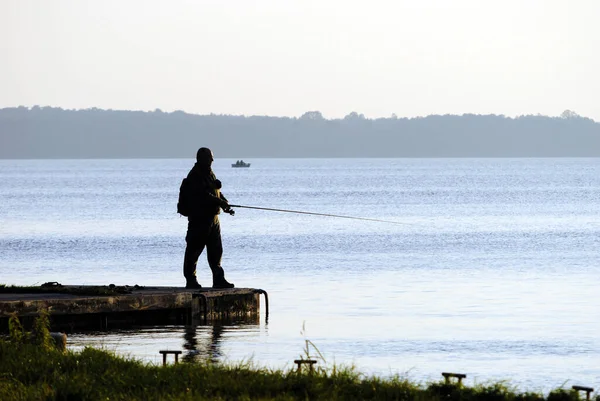 Lublin, Polonya - Nisan 2020: Gölün kıyısında yalnız bir balıkçı