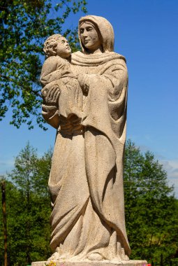 Polonya - Haziran 2018: Tarlalar arasında geleneksel bir yol kenarı türbesi, Meryem Ana, Taş heykel