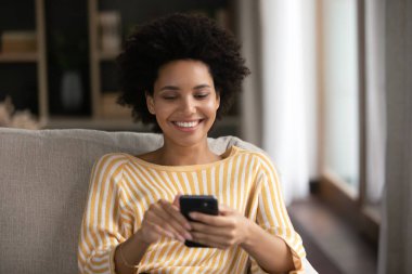 Mutlu, güzel, Afro-Amerikan bir kadın cep telefonu kullanıyor..