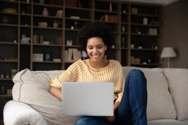 Happy young african american woman using computer. clipart