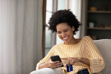 İnternet mağazasından alışveriş yapan mutlu Afro-Amerikalı kadın.