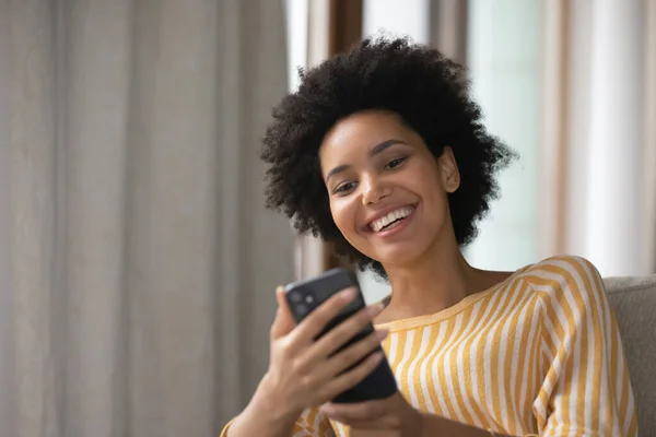 Happy young african american woman using cellphone.