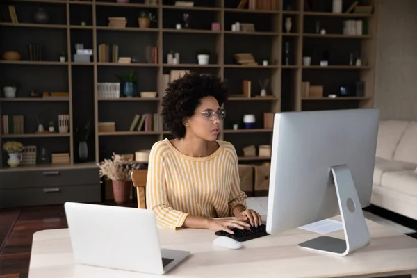 Joven empresaria afroamericana concentrada que trabaja en la computadora. —  Fotos de Stock