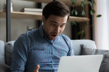 Çok sevinçli, şaşkın bir şekilde dizüstü bilgisayara bakan adamı kapatın.