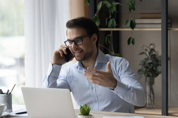 Empresário sorridente de óculos falando por telefone, desfrutando de conversa — Fotografia de Stock