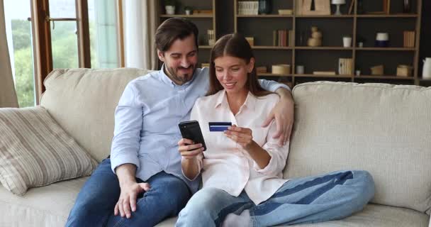 フレンドリーな夫婦は、クレジットカード電話を使用してインターネット決済を行う — ストック動画