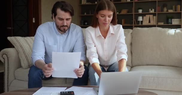 Casal millennial grave envolvido em papelada em casa escritório — Vídeo de Stock