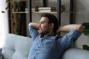 Evdeki kanepede dinlenen hayalperest genç adam.