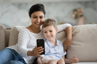 Eğlenceli mobil uygulamalar kullanarak mutlu karışık ırk ailesi.