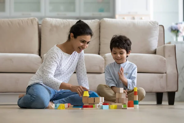 Happy young caring indian mother playing toys with small son. — Stock Photo, Image