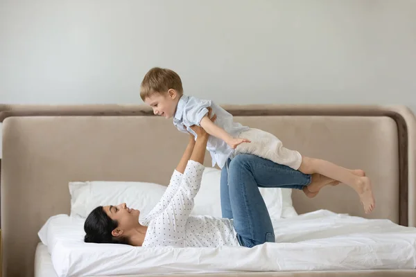 Gelukkig gemengd ras familie doen evenwicht oefeningen in de slaapkamer. — Stockfoto