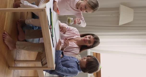 Vrouwelijke babysitter concurreren in het schilderen van foto 's tegen de tijd met kinderen — Stockvideo