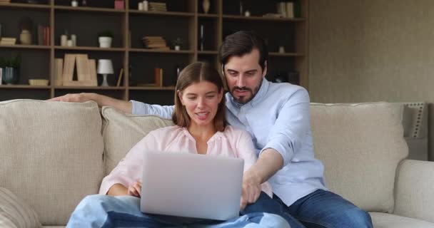 興奮した若い家族のカップルは、ラップトップ画面で素晴らしいニュースを読みました — ストック動画