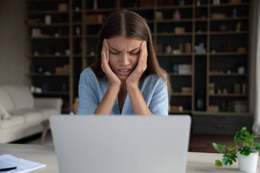 Mutsuz çalışan bilgisayar başında çalışmaktan bıkmış, baş ağrısı çekiyor.