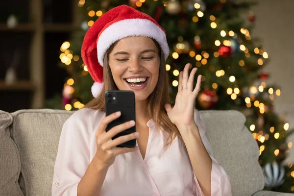 Happy podekscytowany dziewczyna w Santa kapelusz czat na smartfonie — Zdjęcie stockowe