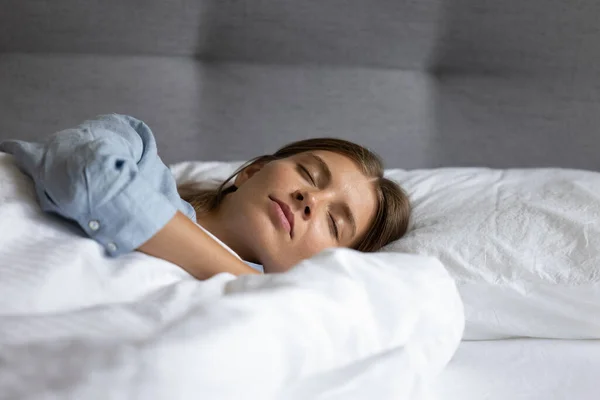 Lugn avslappnad tonåring flicka sover i vitt linne sängkläder — Stockfoto