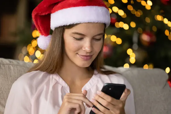 Uśmiechnięte wiadomości tekstowe Christmas girl na smartfonie — Zdjęcie stockowe