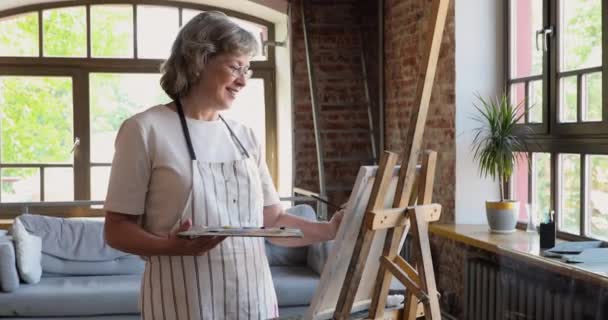 Evde tek başına duran yaşlı kadın sehpaya resim çiziyor. — Stok video