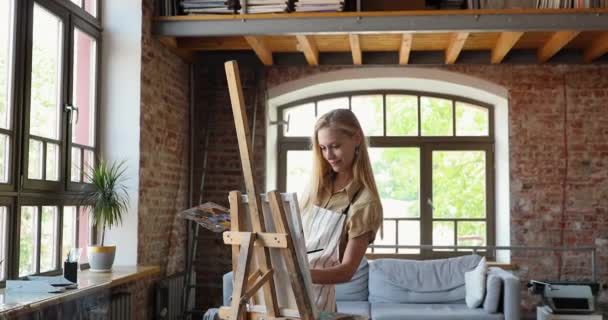 Ung kvinna målning på staffli ensam hemma — Stockvideo