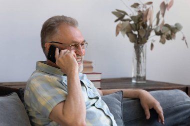 Mutlu orta yaşlı adam telefon görüşmesi yapıyor..