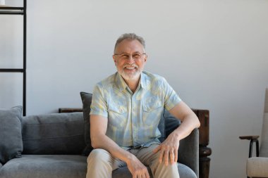 Mutlu, olgun, yaşlı adam rahat koltukta dinleniyor..