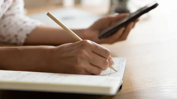 Estudante do sexo feminino escrevendo em notebook, assistindo webinar aprendizagem — Fotografia de Stock