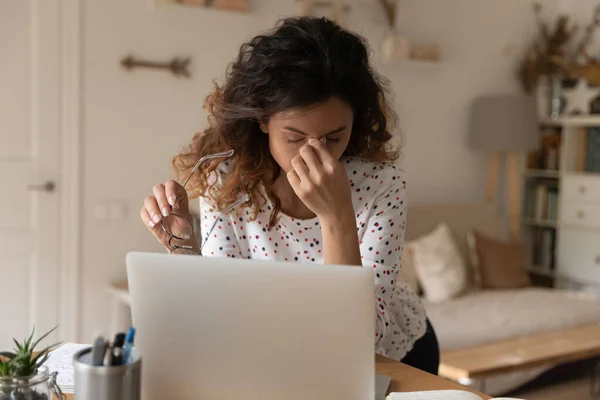 Vrouw moe van het werk op de computer, het afzetten van glazen — Stockfoto