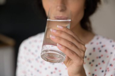 Bardak tutan ve taze soğuk su içen bir kadın eli.