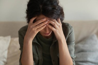 Endişeli genç bir kadın, kişisel sorunları düşünüp depresyona giriyor.