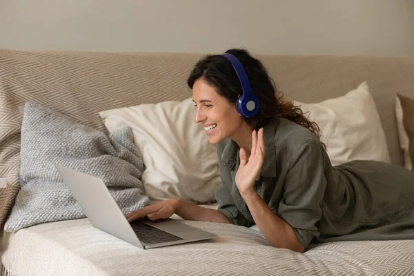 Szczęśliwa kobieta w słuchawkach z laptopem podejmowania rozmowy wideo — Zdjęcie stockowe