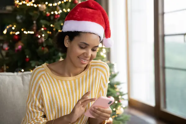 Gelukkig jong Afrikaans amerikaans vrouw met behulp van smartphone thuis. — Stockfoto