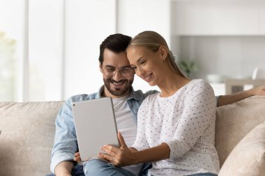 Dijital tablet kullanan mutlu aile çifti.