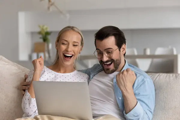 Γελώντας νεαρό παντρεμένο οικογενειακό ζευγάρι κοιτάζοντας την οθόνη του φορητού υπολογιστή. — Φωτογραφία Αρχείου