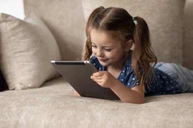 Tablet kullanan mutlu 6lı yaşlardaki küçük çocuk..