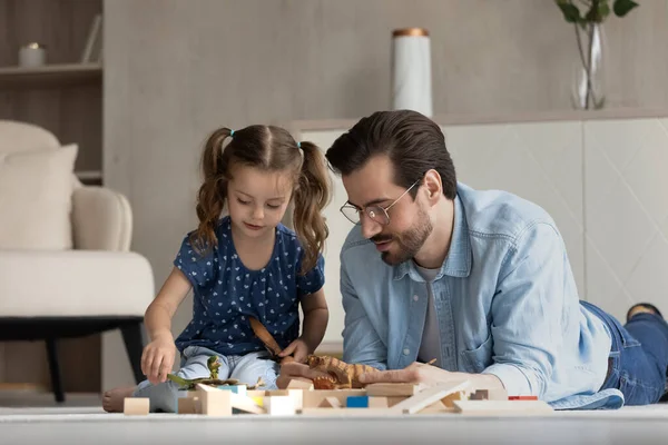 Sorridente premuroso giovane padre giocare giocattoli con il bambino. — Foto Stock